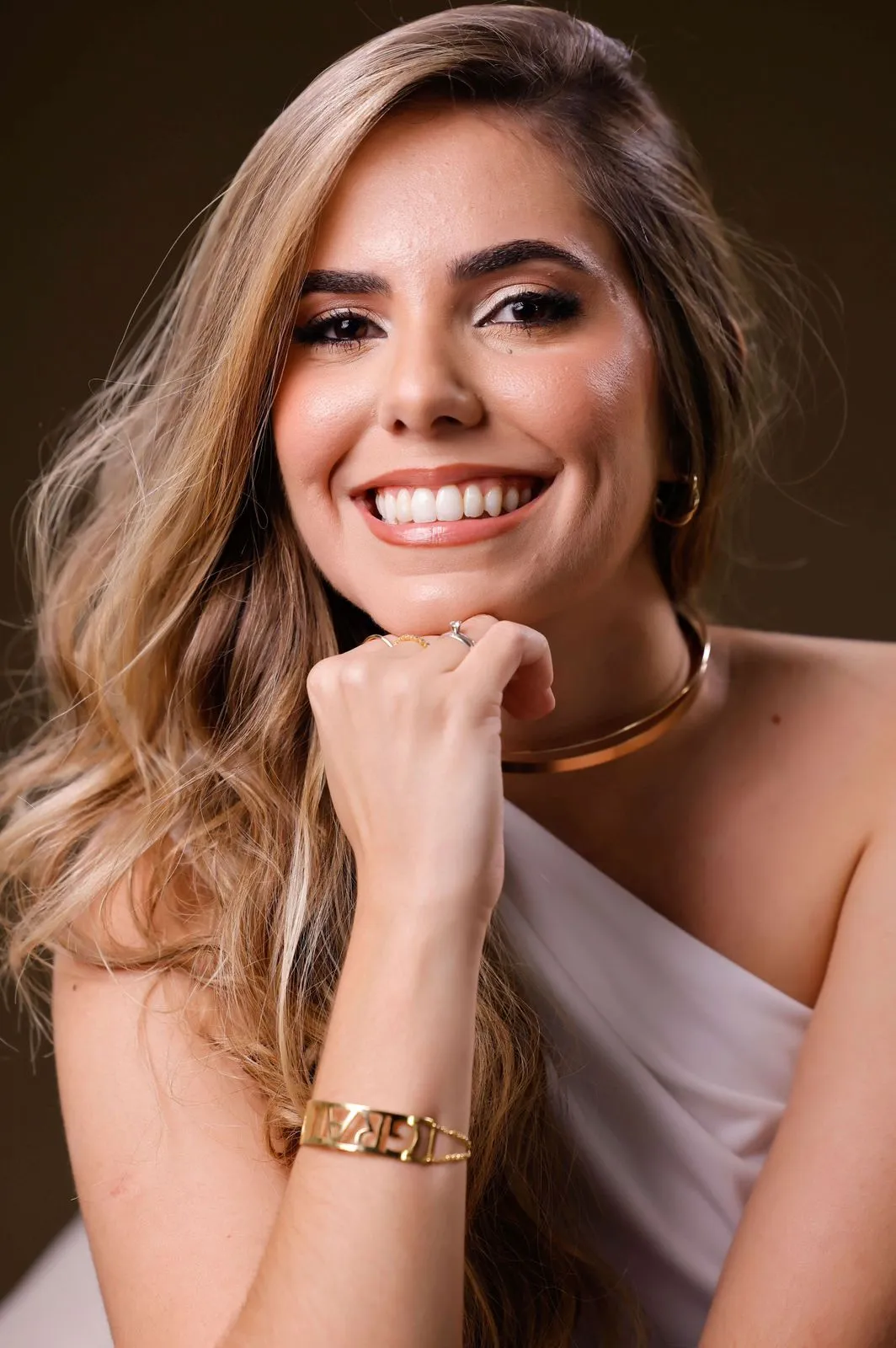 Retrato da nutricionista Carol Ghossi sorrindo, apoiada sobre a mão.